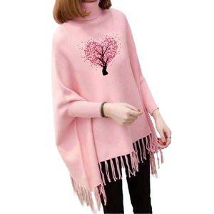 Pink poncho with a heart design and tassels on a white background