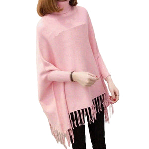 Person wearing a pink poncho with fringe details on a white background