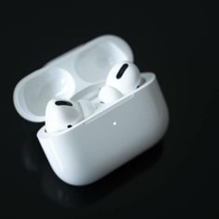 White wireless earbuds in a charging case on a black background